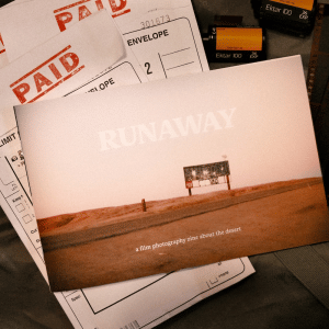 'Runaway' zine cover featuring a full-page photo of an abandoned billboard in the desert at dusk. The title is present along with the caption, 'a film photography zine about the desert'.